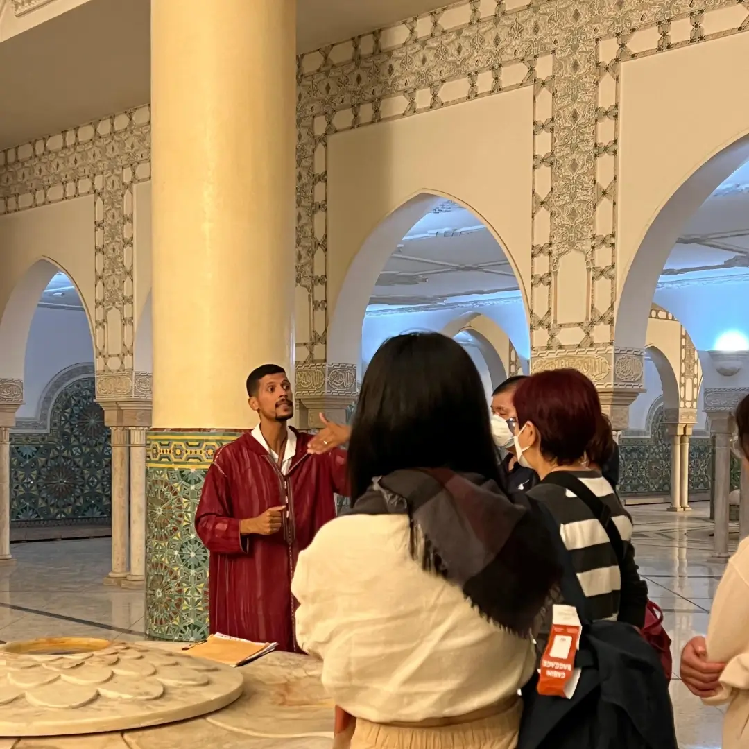 Individual Client 3 A friendly, expert Morocco tour guide from Visit Morocco Tours smiles and talks with a small group of happy travellers. Visit Morocco Tours