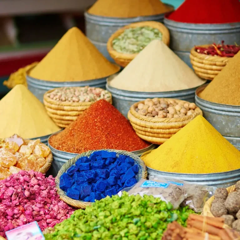 Vibrant display of colorful Moroccan spices in market stalls Marrakech. Visit Morocco Tours