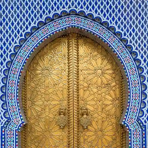 Intricate golden doors and bronze craftsmanship at the Royal Palace in Fez Morocco. Visit Morocco Tours