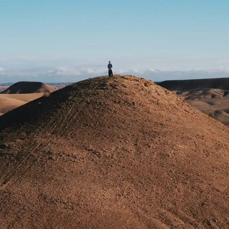 Visit Morocco Tours - Panoramic view of Agafay stone desert with Atlas Mountains in background. Visit Morocco Tours