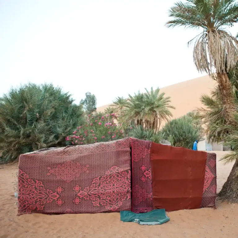 A traditional Berber tent set against the golden sand dunes of Merzouga in the Sahara Desert, Morocco. Visit Morocco Tours