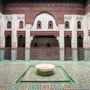 Bou Inania Madrasa Guided Tour: courtyard with intricate Moroccan architecture. Visit Morocco Tours