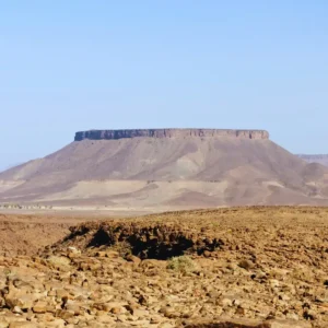 The endless, sun-scorched rocky plains of the Hamada du Draa desert in southern Morocco, under a vast sky. Visit Morocco Tours