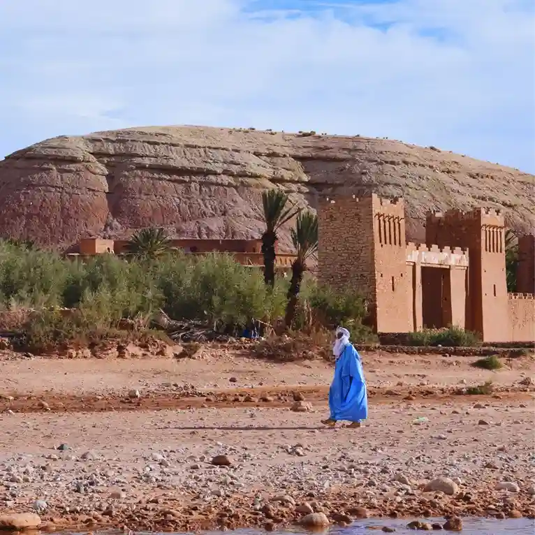 Visit Morocco Tours - Local guide leading a tour through the ancient ksar of Ait Benhaddou, Morocco. Visit Morocco Tours